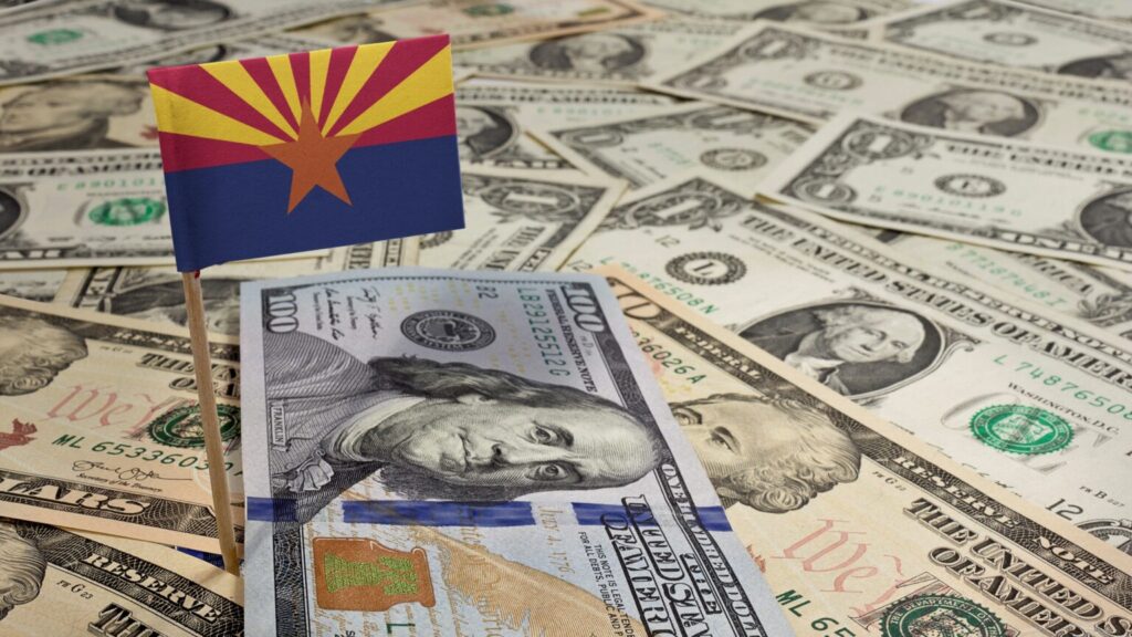 lots of paper money with an arizona flag posted overtop