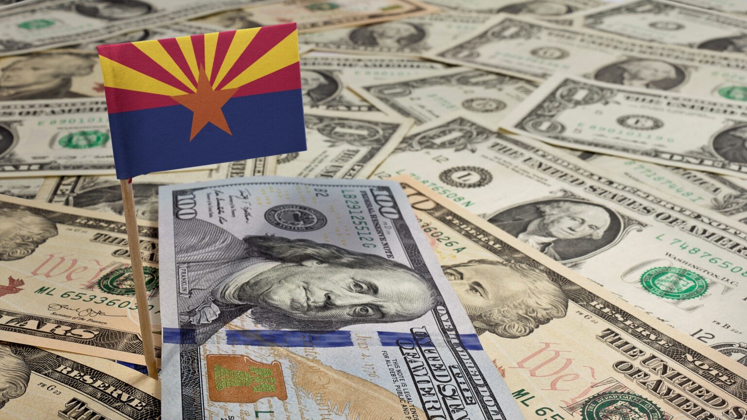 lots of paper money with an arizona flag posted overtop