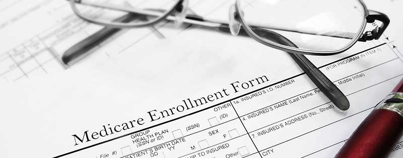 Medicare enrollment form with eye glasses laying on top